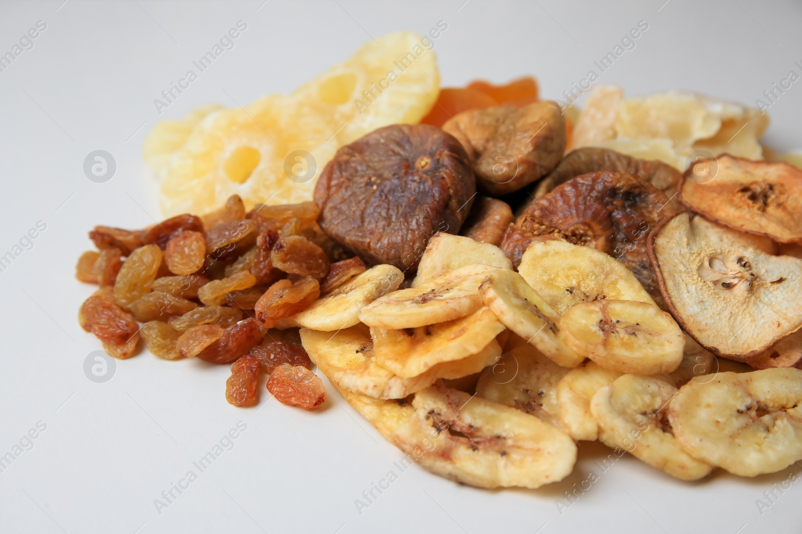 Photo of Pile of different dried fruits on white background, closeup