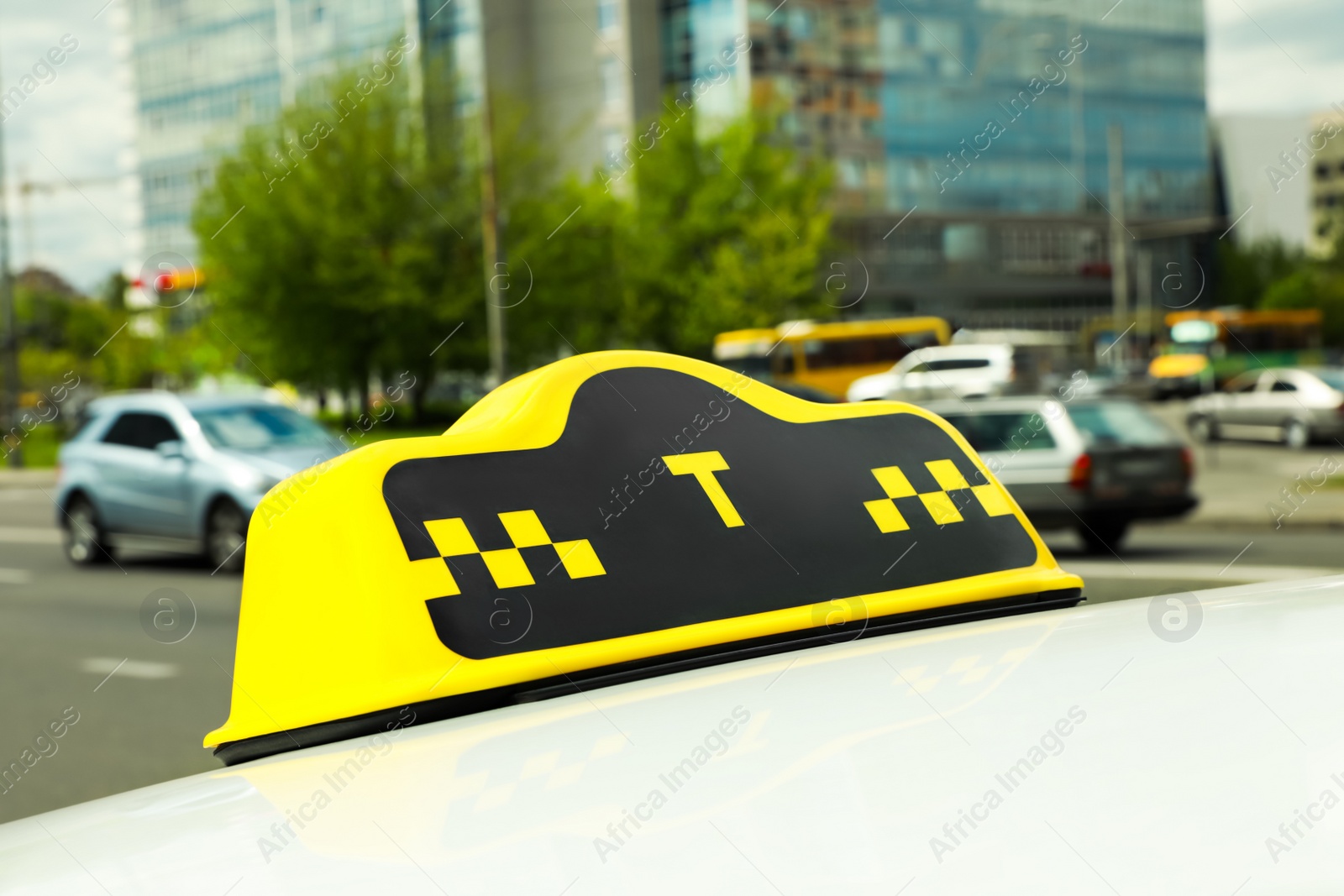 Photo of Taxi sign on car roof in city, closeup view