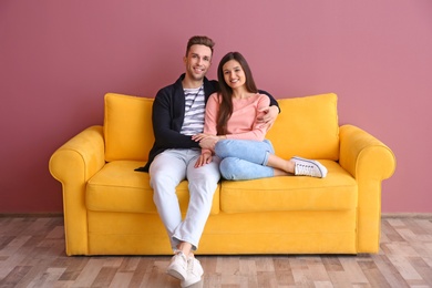 Photo of Happy young couple sitting on sofa, indoors