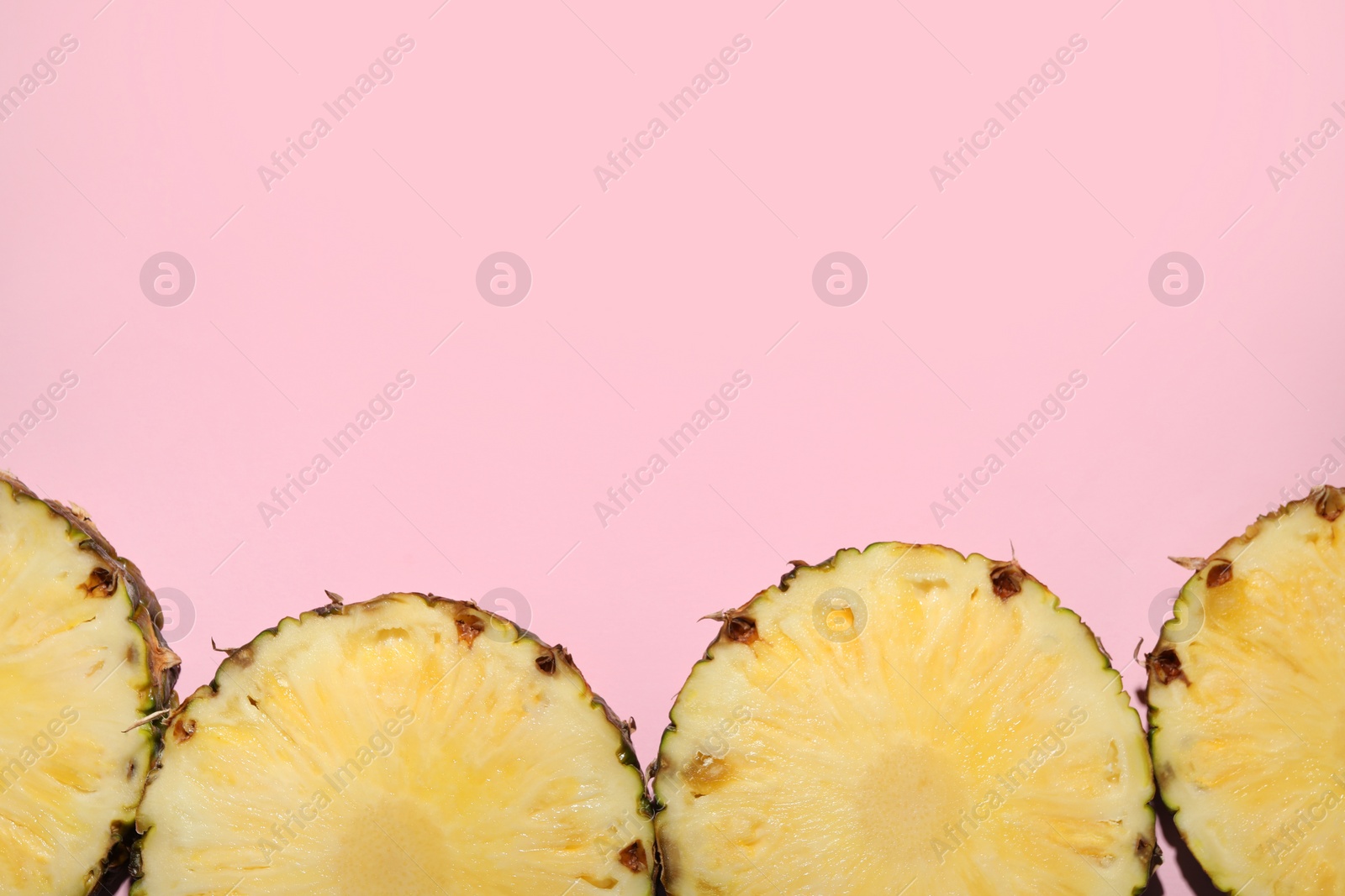 Photo of Slices of tasty ripe pineapple on pink background, flat lay. Space for text