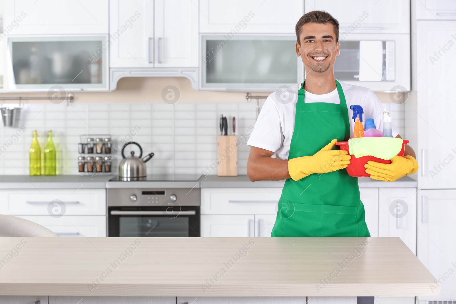 Photo of Man with basin and cleaning supplies in kitchen
