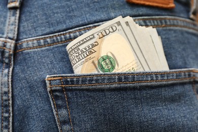 Photo of Dollar banknotes in pocket of jeans, closeup. Spending money