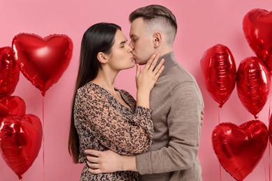 Lovely couple kissing on pink background. Valentine's day celebration