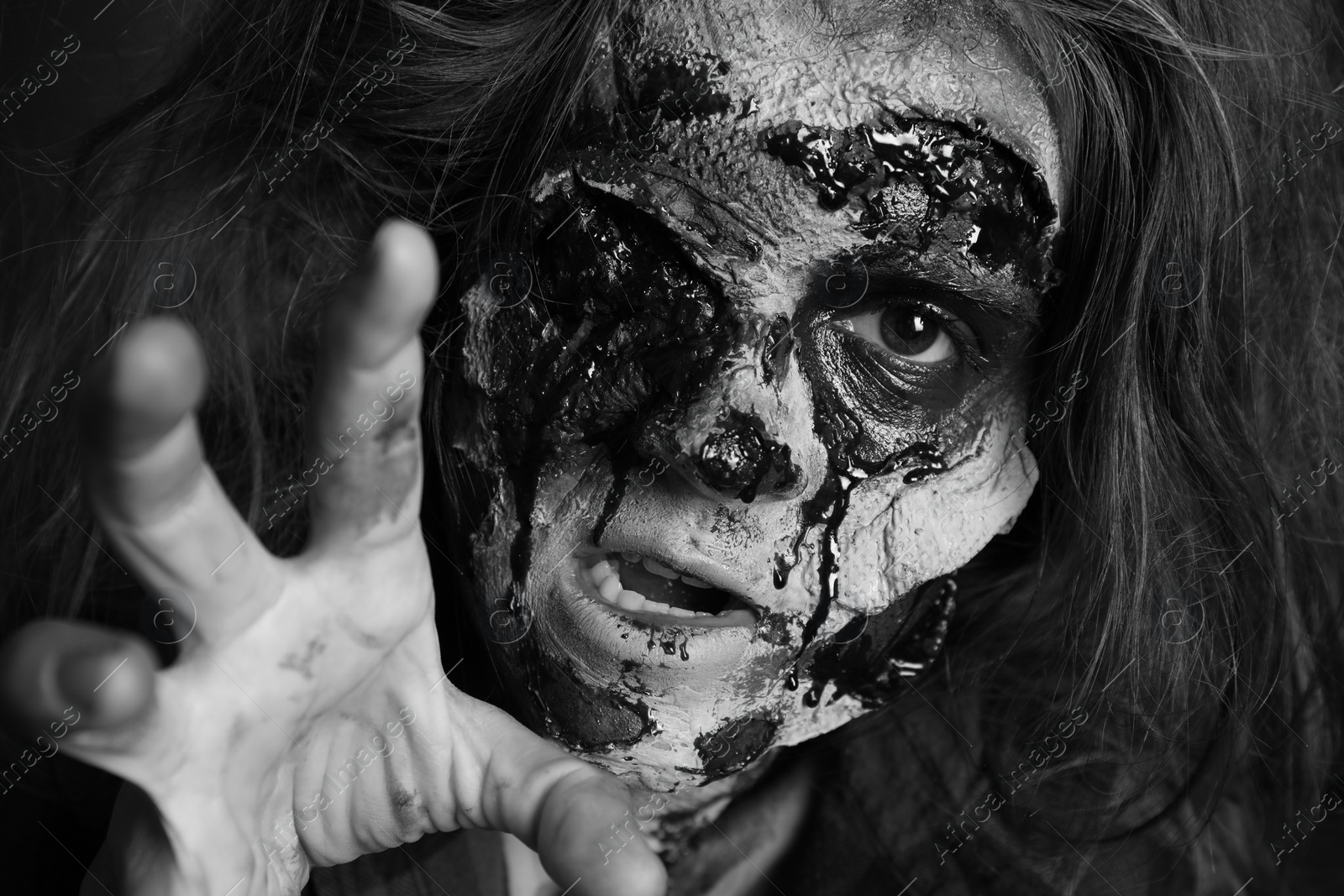 Photo of Scary zombie with bloody face, black and white effect. Halloween monster