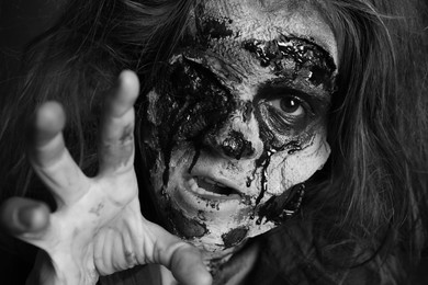 Photo of Scary zombie with bloody face, black and white effect. Halloween monster