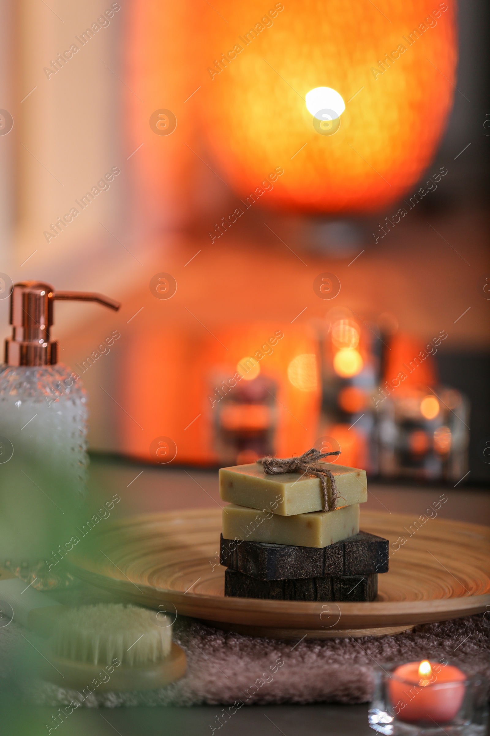 Photo of Dish with soap bars on table against blurred background. Space for text