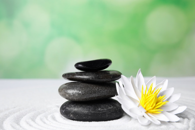 Zen garden. Beautiful lotus flower and stones on white sand