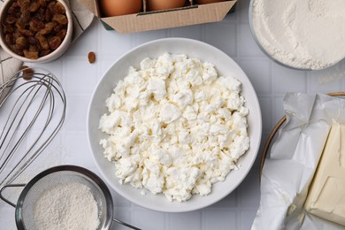 Photo of Different ingredients on white tiled table, flat lay. Cooking cottage cheese pancakes