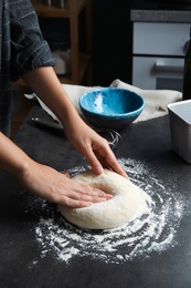 Woman kneading dough for pastry on table