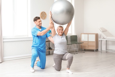 Photo of Physiotherapist working with patient in clinic. Rehabilitation therapy