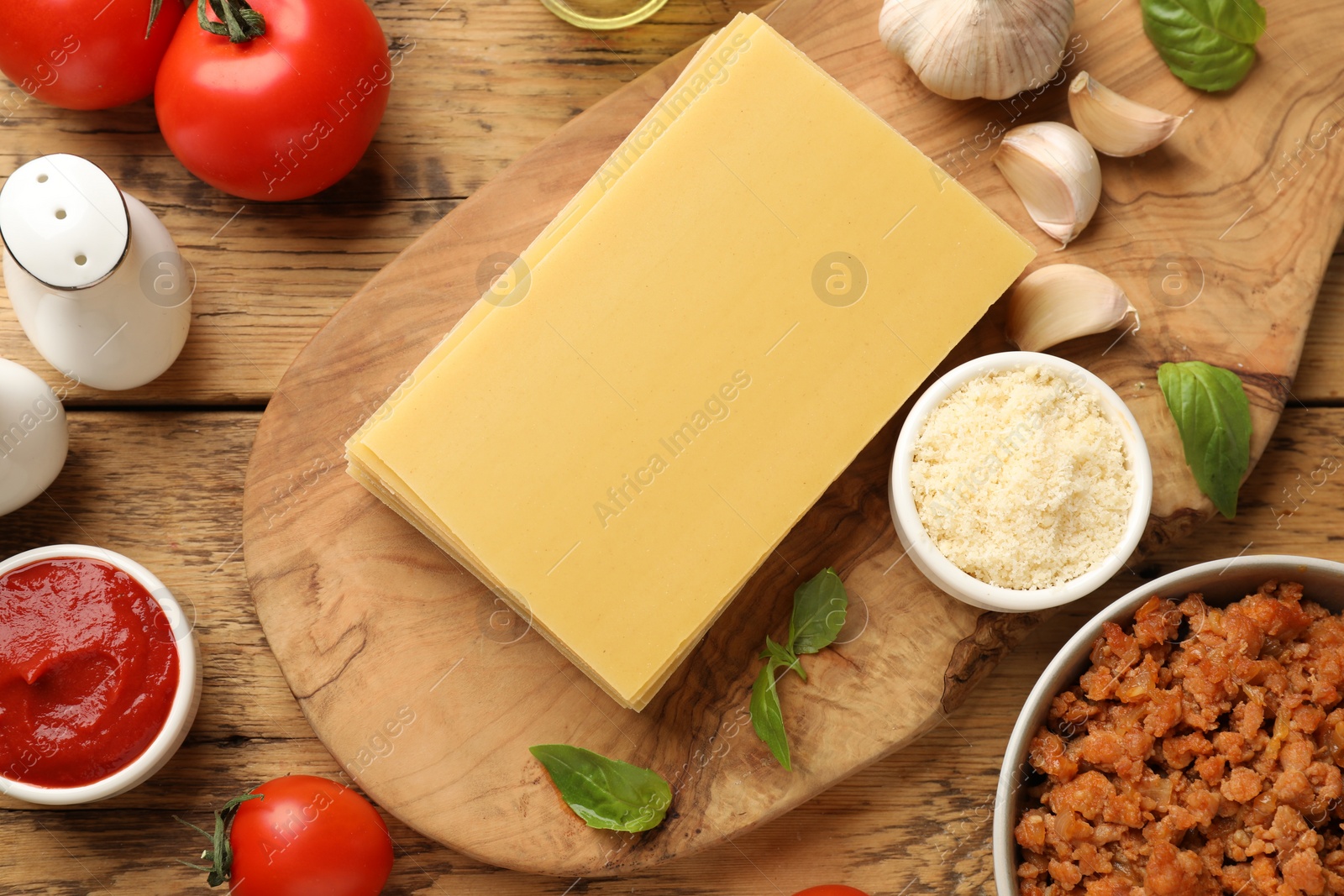 Photo of Flat lay composition with products for cooking lasagna on wooden table