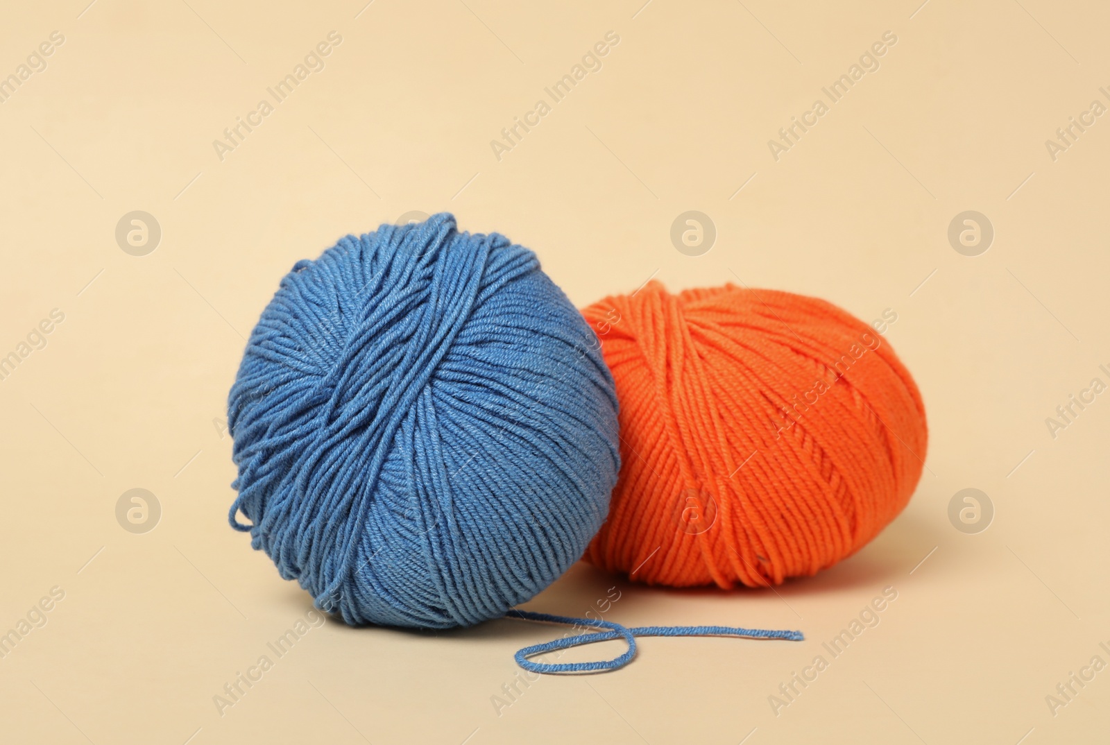 Photo of Soft colorful woolen yarns on beige background