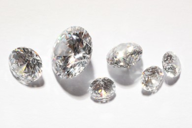 Photo of Many beautiful shiny diamonds on white background