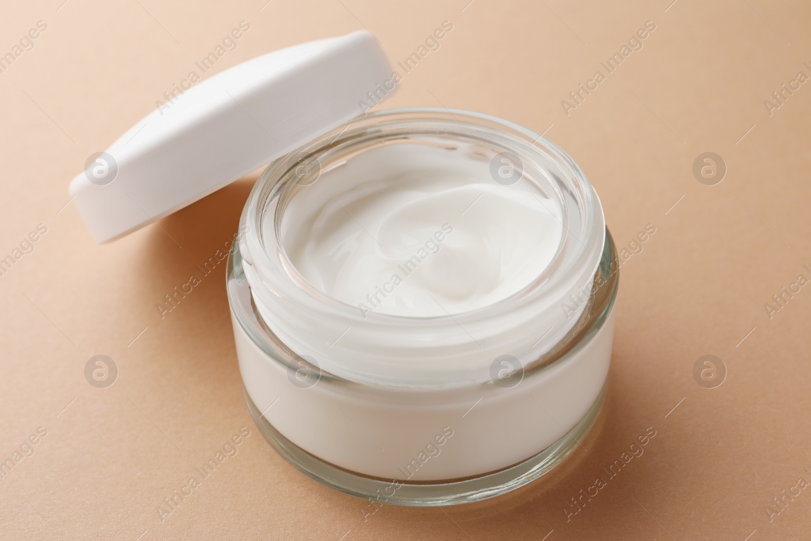 Photo of Jar of face cream on beige background, closeup