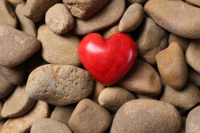 Red decorative heart on stones, top view