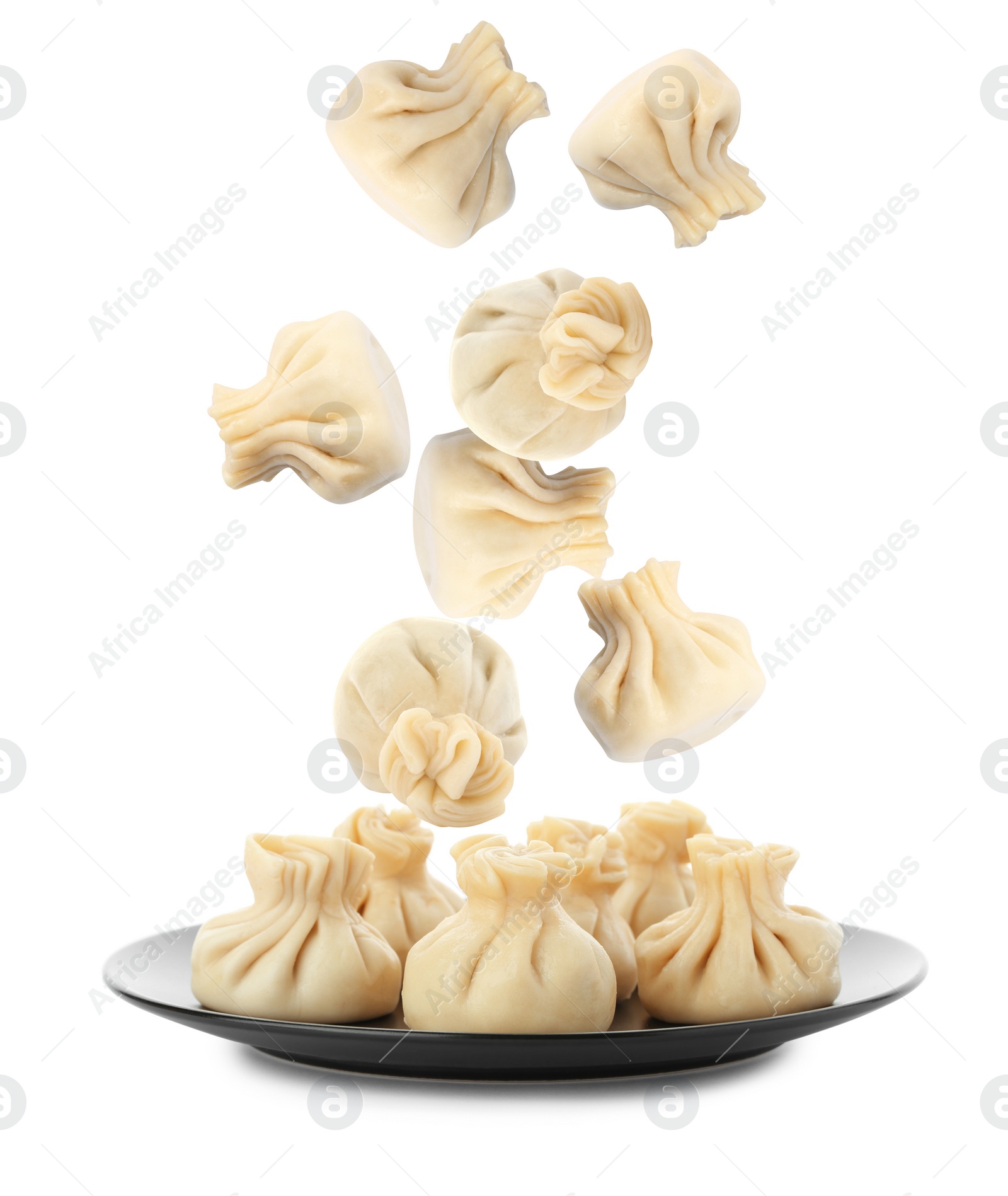 Image of Many tasty dumplings falling on white background