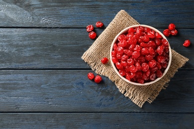 Photo of Bowl of tasty cherries on wooden background, top view with space for text. Dried fruits as healthy food