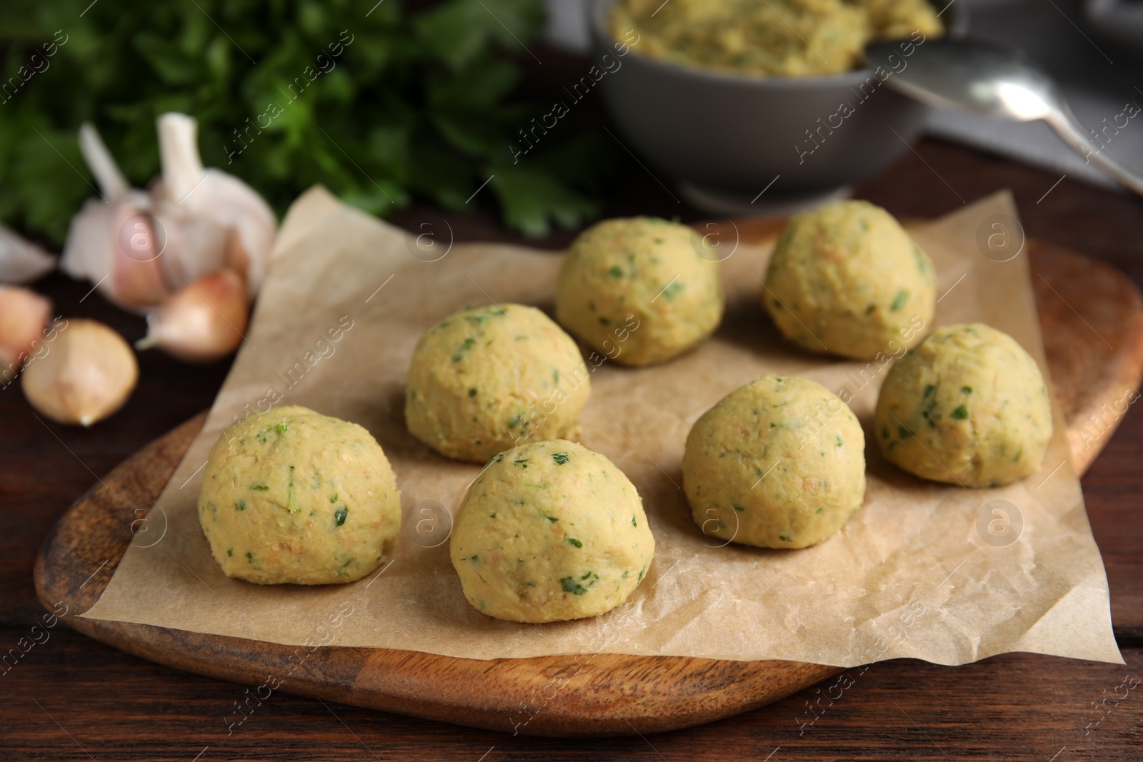 Photo of Many raw falafel balls on wooden table