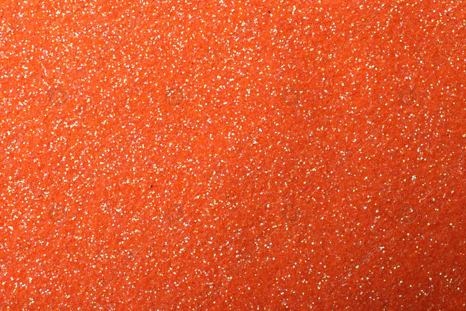 Photo of Beautiful shiny orange glitter as background, closeup