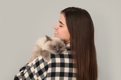 Photo of Woman with her cute cat on light grey background