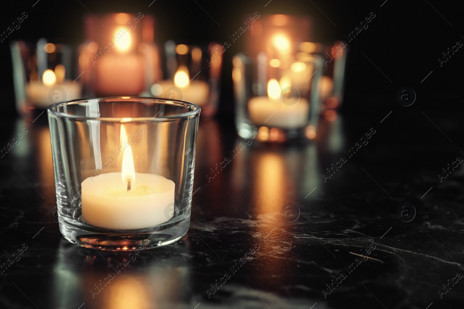 Photo of Burning candle on table in darkness, space for text. Funeral symbol