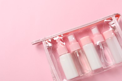 Cosmetic travel kit in plastic bag on pink background, top view. Space for text