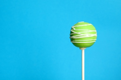 Bright delicious cake pop on color background. Space for text