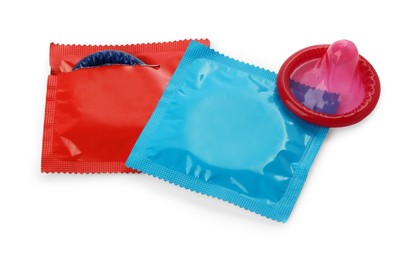 Photo of Unwrapped and packaged condoms on white background. Safe sex
