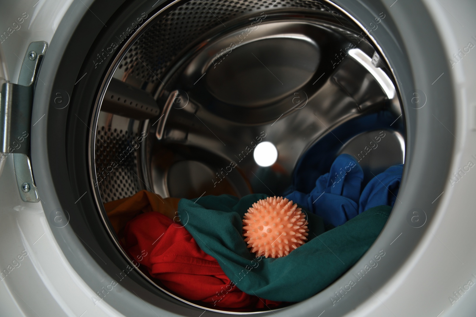 Photo of Dryer ball and clothes in washing machine, closeup