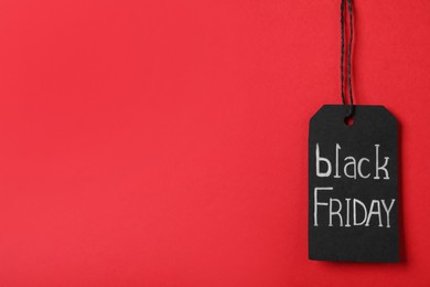 Black Friday tag on red background, space for text