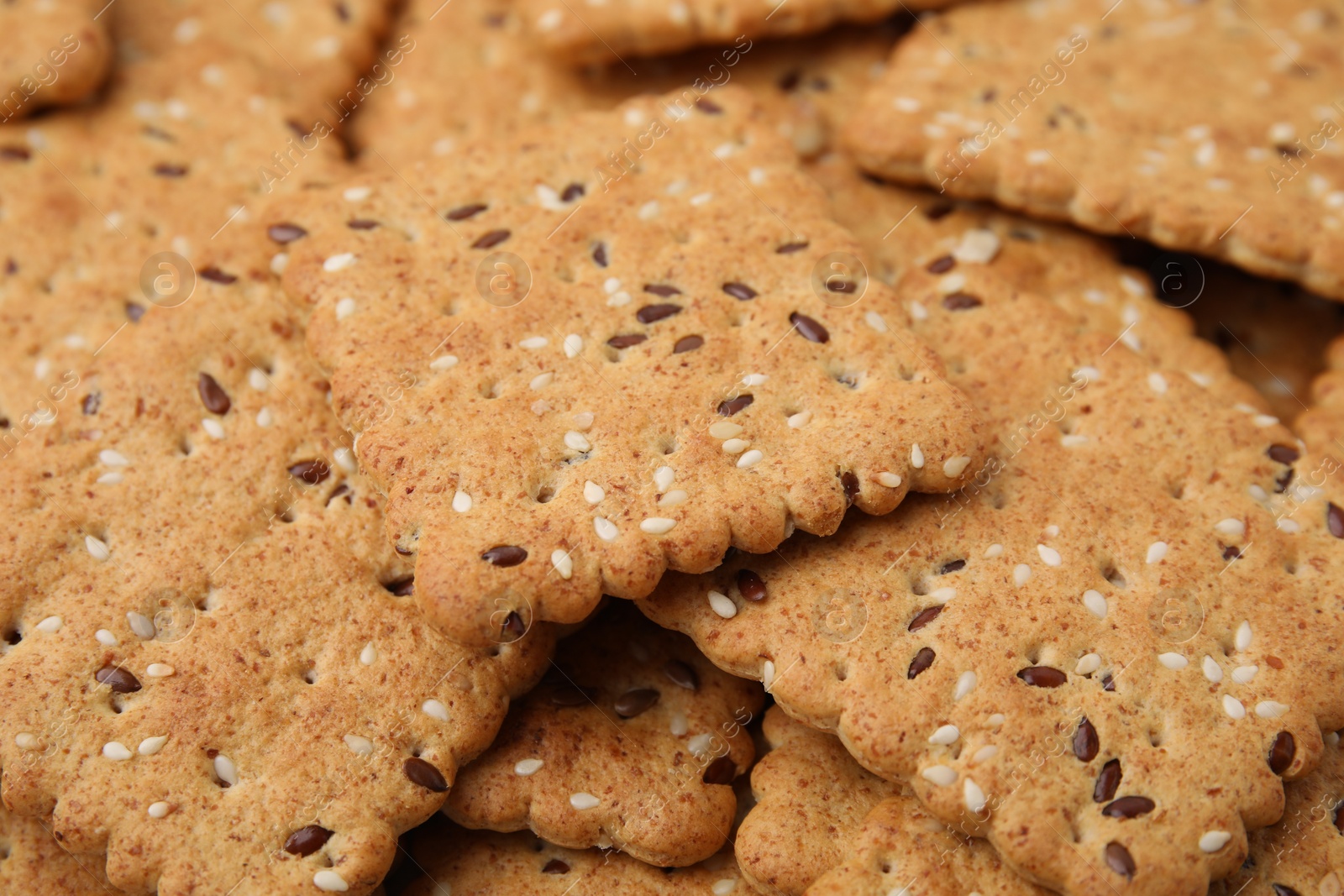 Photo of Cereal crackers with flax and sesame seeds as background, closeup