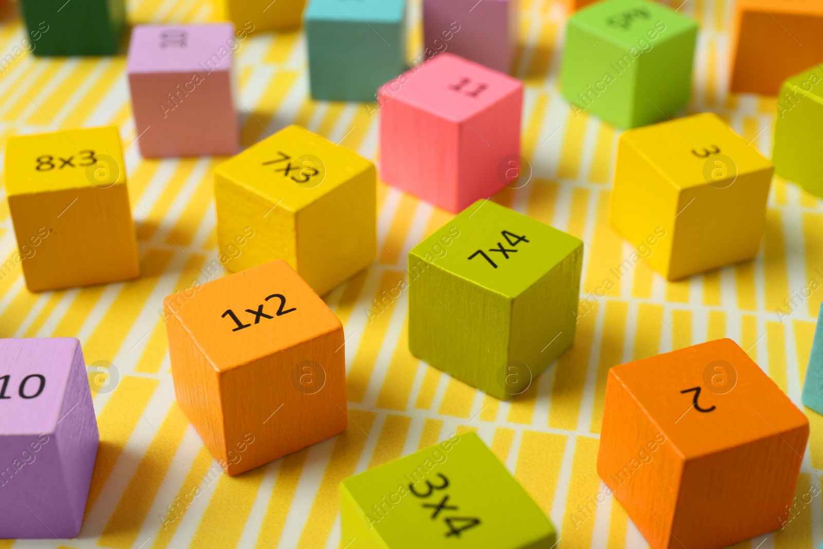 Photo of Colorful cubes with numbers and multiplications on yellow background