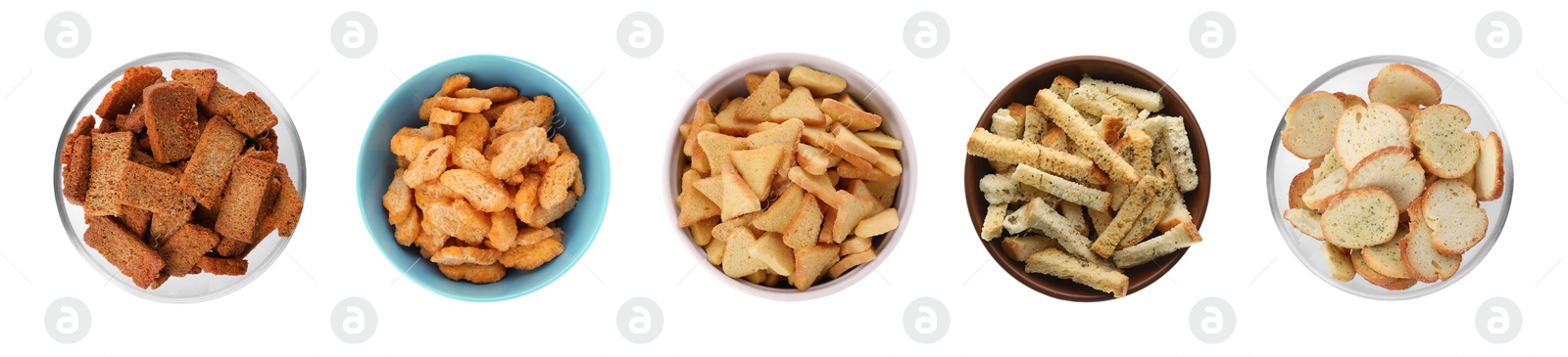 Image of Set with different delicious crispy rusks on white background, top view. Banner design