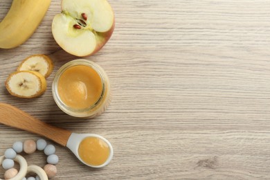 Photo of Tasty baby food in jar and ingredients on light wooden table, flat lay. Space for text