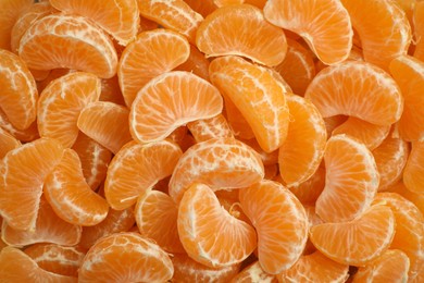 Photo of Delicious tangerine segments as background, top view