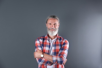 Photo of Handsome bearded mature man on color background