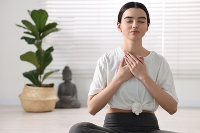 Portrait of beautiful girl meditating in yoga studio