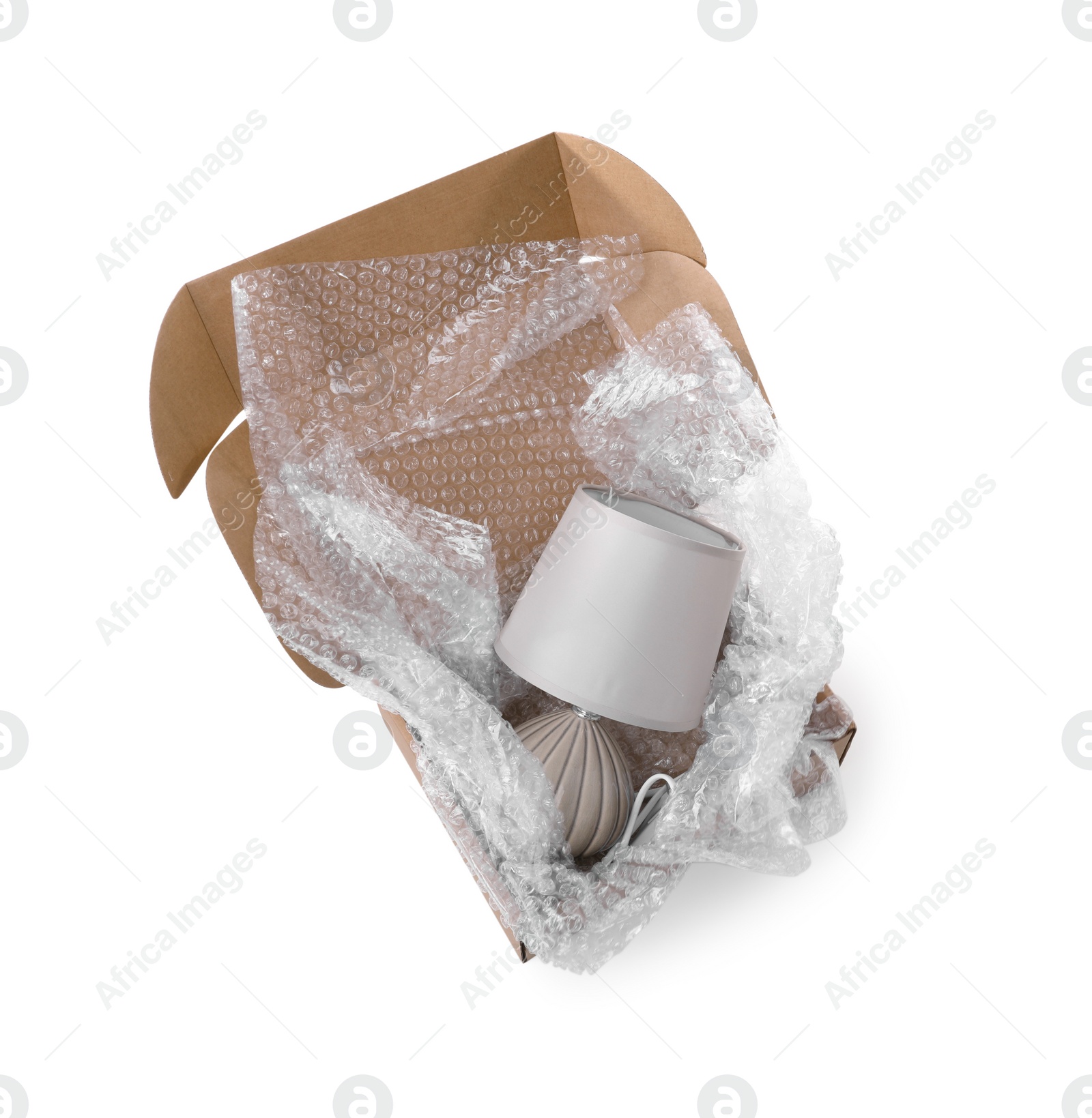 Photo of Lamp with bubble wrap in cardboard box isolated on white, above view