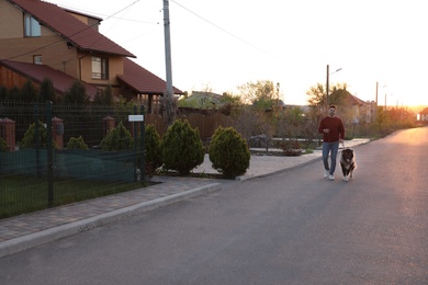 Young man walking his Caucasian Shepherd dog outdoors