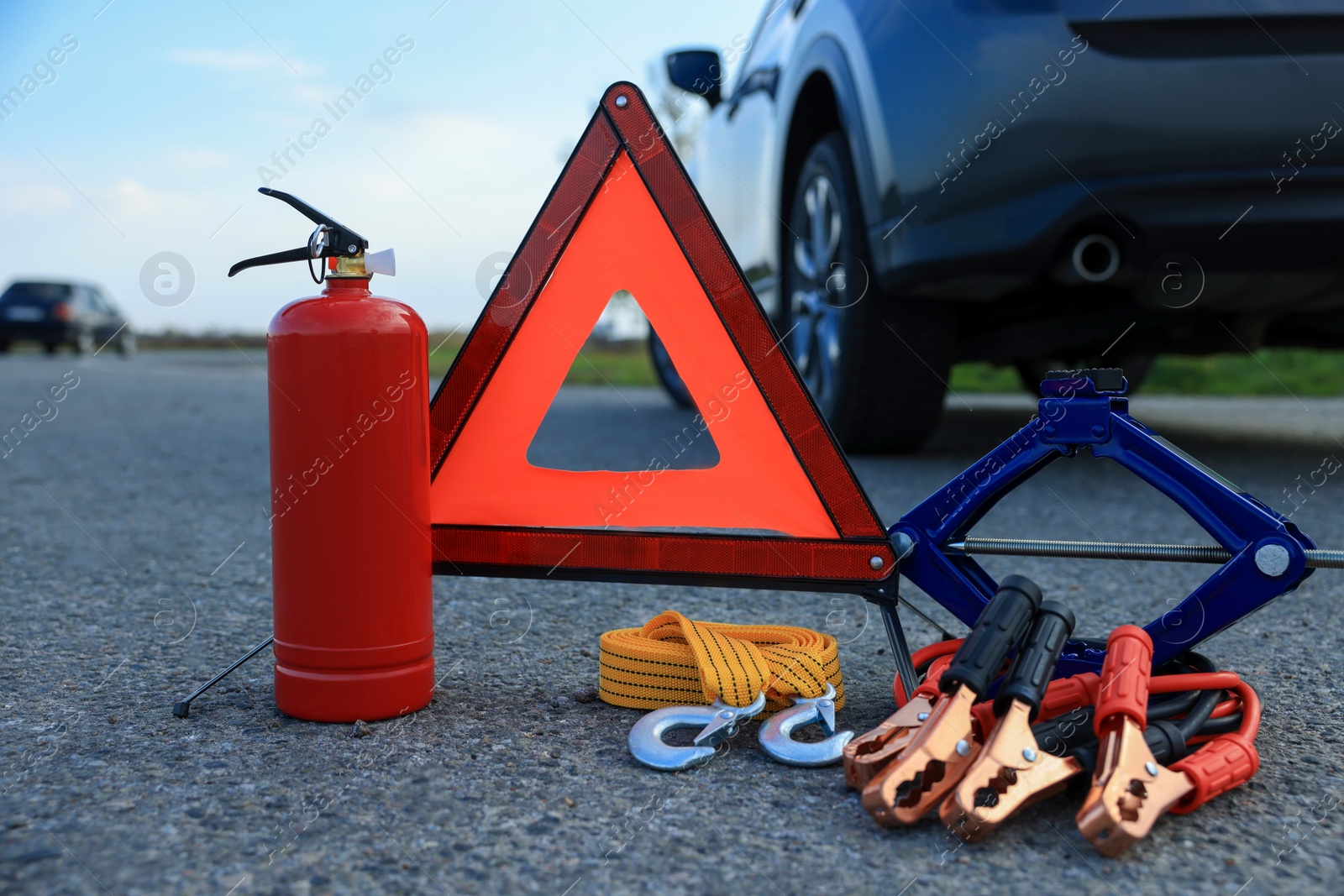 Photo of Emergency warning triangle and car safety equipment outdoors