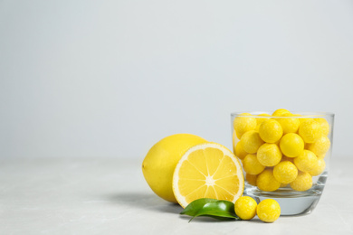 Photo of Composition with lemon drops on grey marble table. Space for text