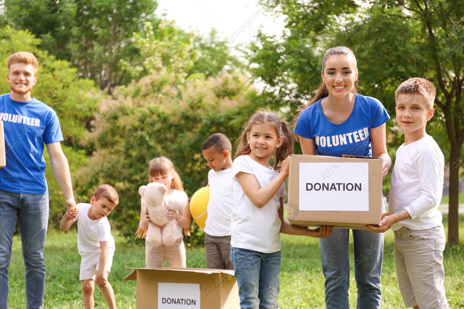 Photo of Volunteers and kids with donation boxes in park