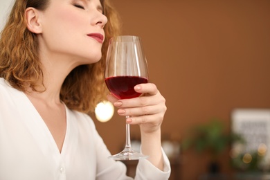 Photo of Woman with glass of delicious wine indoors