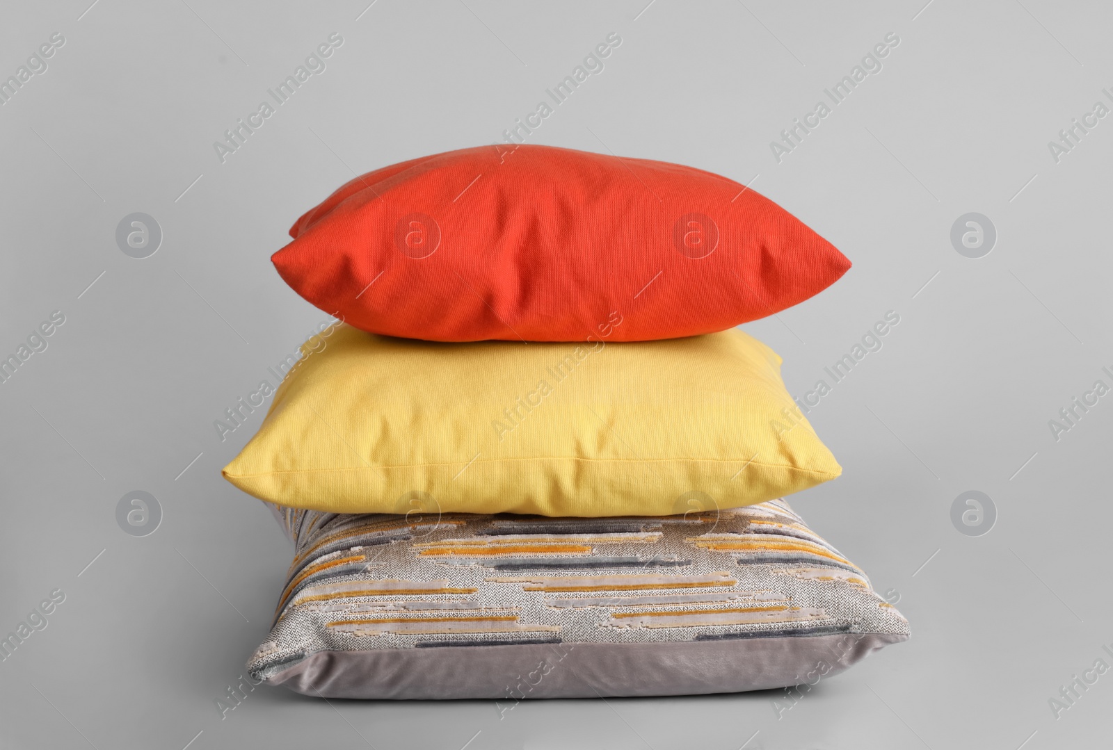 Photo of Stack of stylish soft pillows on grey background