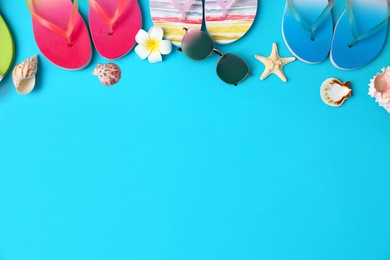 Photo of Flat lay composition with different flip flops on blue background, space for text. Summer beach accessories