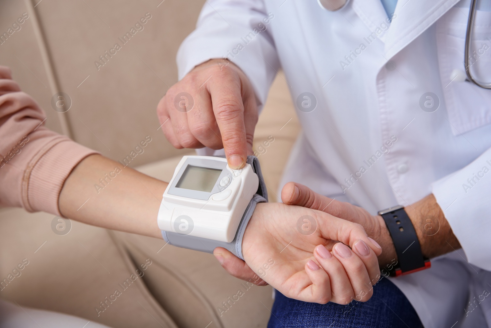 Photo of Doctor checking young woman's pulse with medical device indoors, closeup