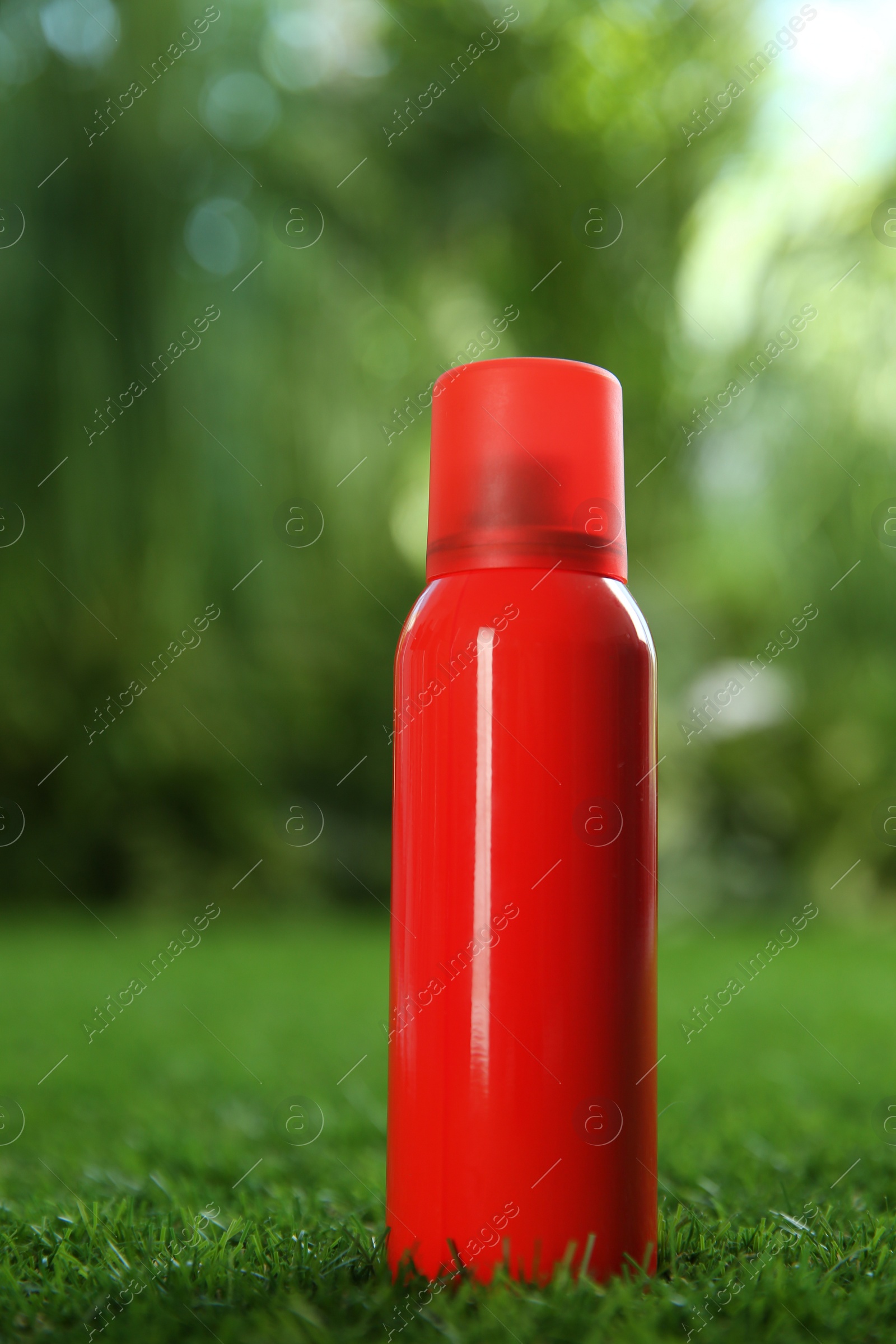 Photo of Bottle of insect repellent spray on green grass