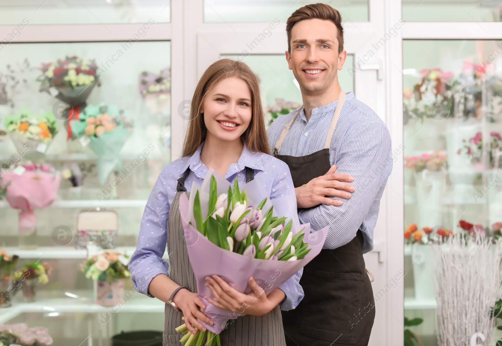 Photo of Male and female florists with bouquet flowers at workplace