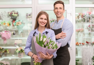 Photo of Male and female florists with bouquet flowers at workplace