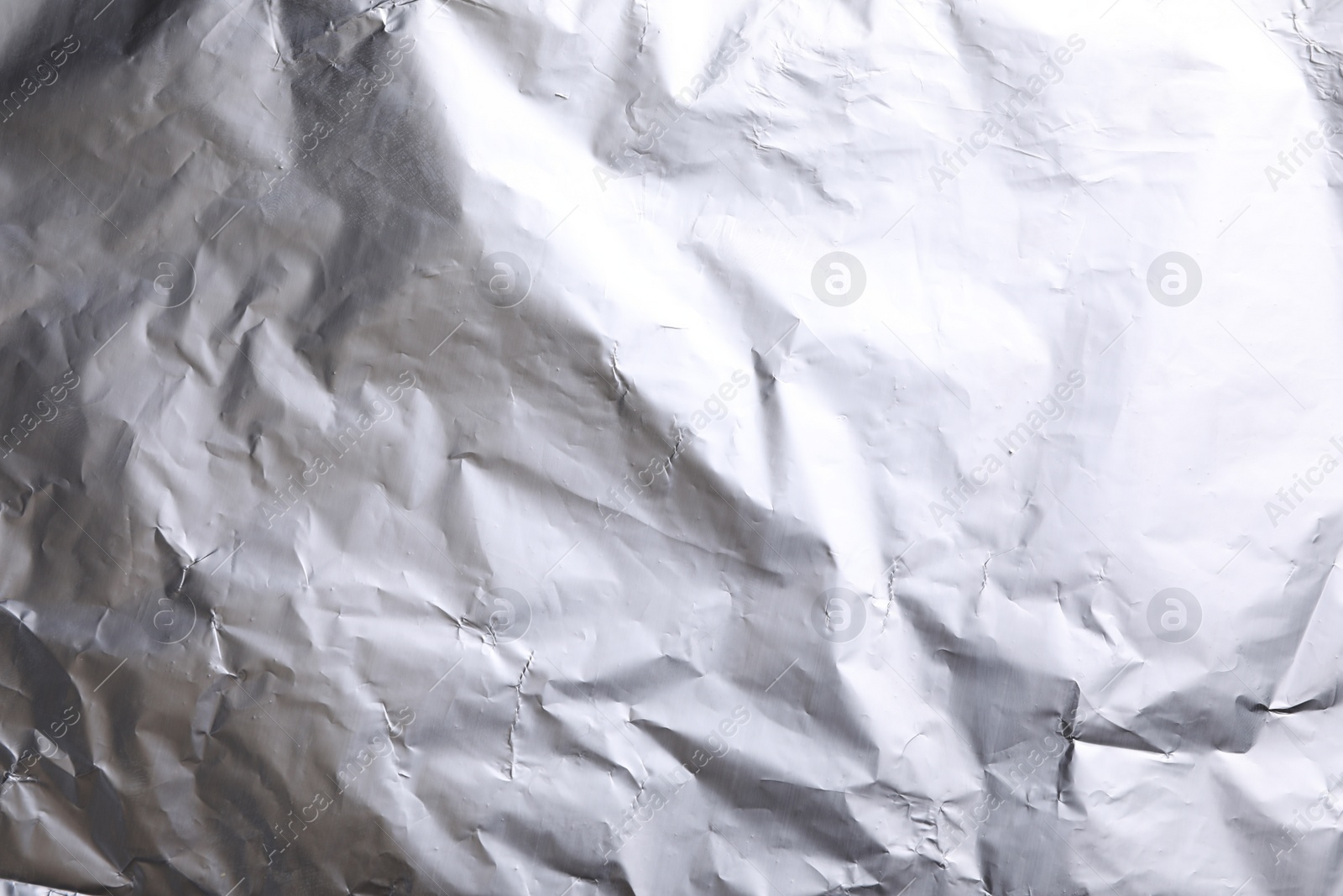 Photo of Crumpled silver foil as background, closeup view